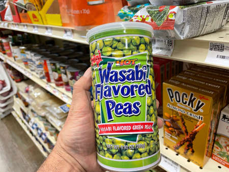 Grovetown, Ga USA - 03 20 22: Retail store shelves hand holding can of wasabi peasのeditorial素材