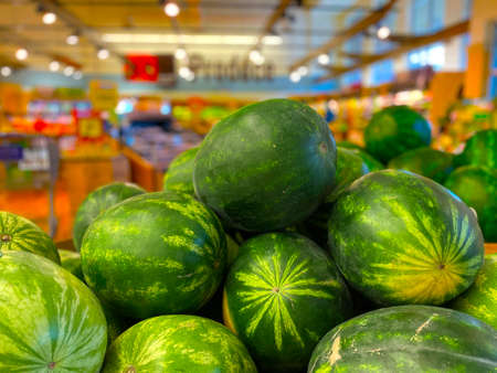 Retail store fresh produce watermelons and colorful backgroundの写真素材