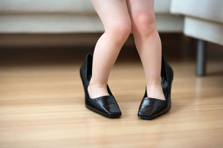 Little child wearing big shoesの写真素材