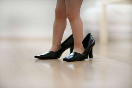 Little child wearing big shoesの写真素材