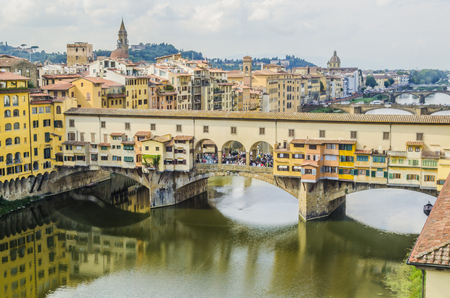 view of the bridge vecchio of florence and successive bridges crossing the river arno and other constructions of the city of the background the mountains of tuscanyの写真素材