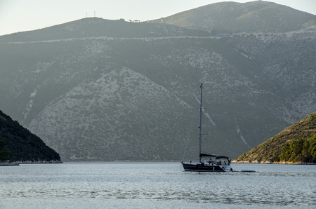 Sailboat sailing in the Ionian sea between the Ionian islands and their elevations nearly to the...