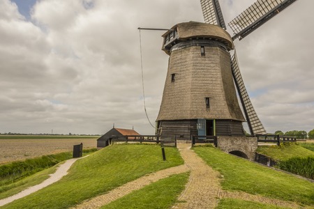 landscape with carved fields and close-up of typical dutch windmill. Oterleek netherlands hollandの写真素材