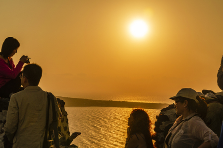 SANTORINI, GREECE - October 9, 2014: Sunset in the village of Oia. Tourists enjoying the sundown over the Aegean sea on the island of Santorini.のeditorial素材
