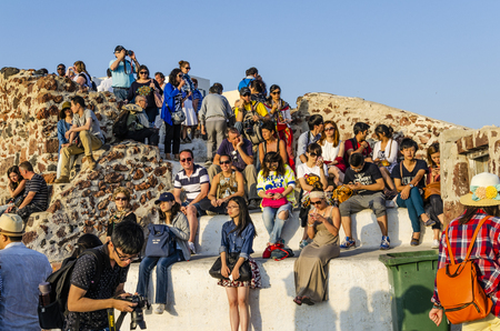SANTORINI, GREECE - October 9, 2014: Sunset in the village of Oia. Tourists come to this point and wait for the sun to fall on the sea to photograph one of the most beautiful landscapes in the world.のeditorial素材