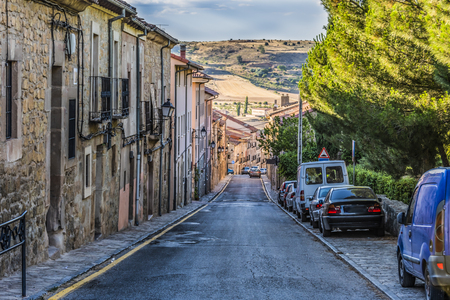 Typical street in descent in the city of Siguenza and in the background the hills of Guadalajara. Castilla La Mancha Spainの写真素材