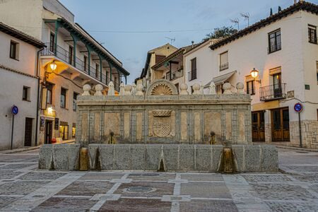 Old fountain with emblematic shields of the town of Chinchon in the main square. Madrid's community. Spain.の写真素材