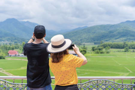 Nan, Thailand-October 18, 2020: Two unidentified tourists using a smartphone for taking photos view...