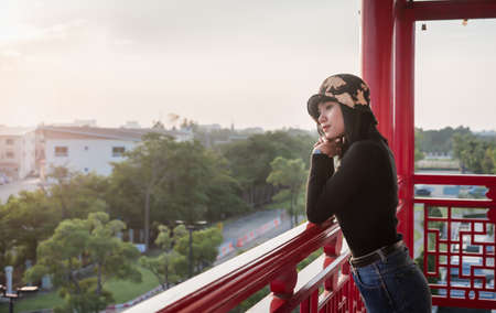 Portrait of happy young woman relaxing on the viewpoint with breathtaking view over city at the...