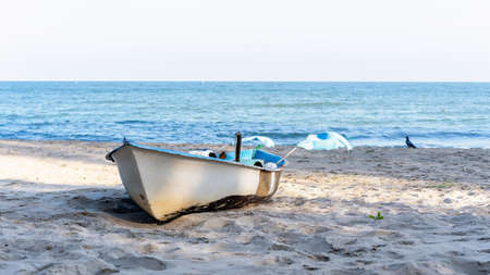 Small fishing old rowboat on blue sky and sea beach background with copy space - Holiday concept