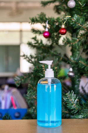 Alcohol sanitizers or alcohol gel from pump bottle in public area with Christmas tree background for prevention and control coronavirus (COVID-19) outbreak infection  Hygiene and health care conceptの写真素材