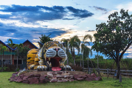 Ratchaburi, Thailand-January 29,2021: Beautiful sculpture of tiger statue at sunset sky on blue and...