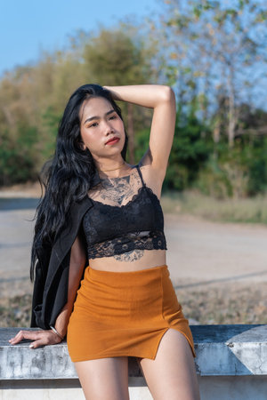 Portrait of happy young woman wearing fashionable clothes. Young stylish female model posing sexy with tattoo on body outdoors in nature background. Lifestyle and positive human emotion concept.の写真素材