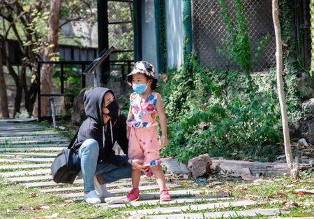 Asian child girl and young woman wearing protective medical mask in public area at risk of disease, people prevent infection from leisure concept.の写真素材