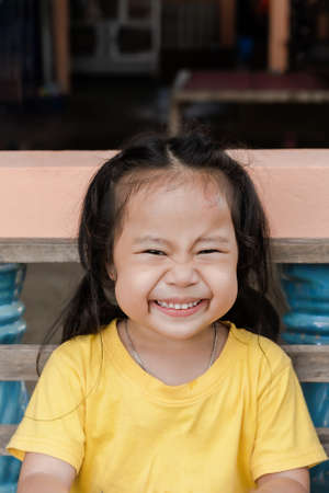 Portrait of adorable child Asian woman luaghing, happy cute little girl with  big smiling and looking to camera. Positive kid posing at home for photo, feeling happy, cheerful funny childの写真素材