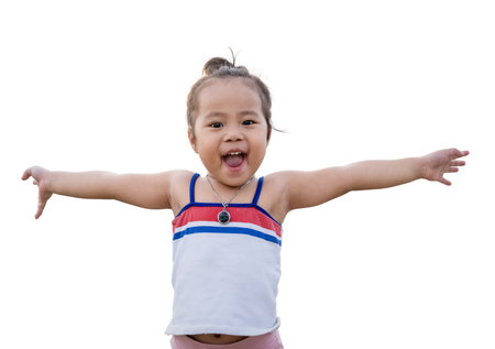 Happy Asian little girl having fun and raising hands up with her face to surprise and excited for something. Excited girl with raised arm having fun to play with isolated on white background.の写真素材