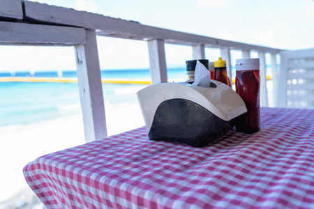 Close-up of straw hat against blurred blue sea background on balcony of the restaurant beside beach....