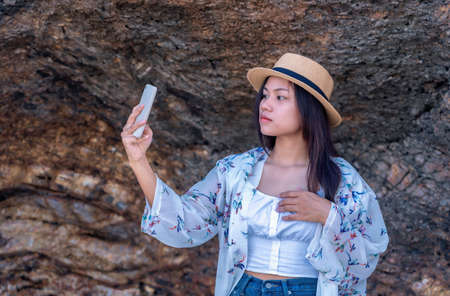 Happy woman wearing straw hat relaxing and watching views of sea and sky on tropical beach travel summer holidays. Beautiful young model tourist enjoy traveling to exotic nature in leisure time.の写真素材