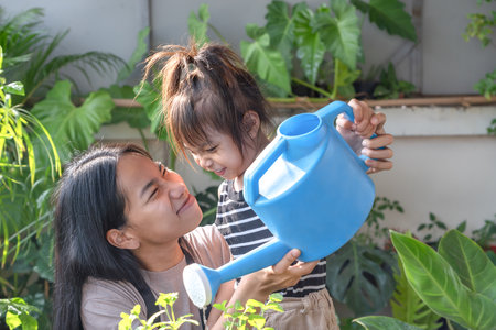 Asian daughter and mother having fun planting flowers together and taking care of home plants. Real people's domestic life family, gardening concept, Lifestyles conceptの写真素材