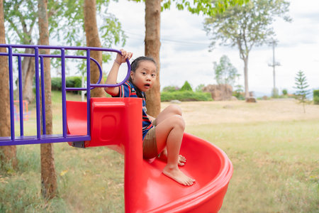 Little girl, age 5-7 years old, cute, funny, crazy, playing on toys at school or kindergarten or playground. Healthy summer activities. Outdoor play. Happy children. Relaxation. Childhood concept.の写真素材