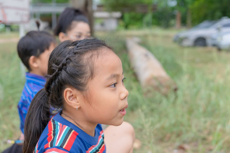 A young child sat in the park with a curious expression on his face. His eyes widened. While staring around the child thought deeply. and was pondering something that caught his attention.の写真素材