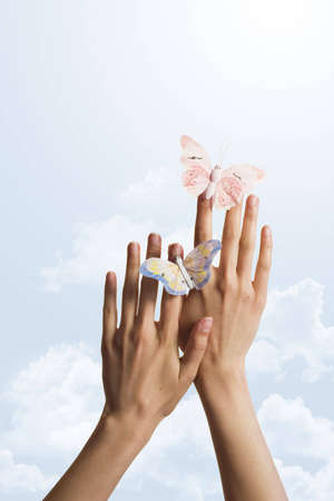 two butterflies on hands over the sky  