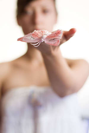 young female is holding butterfly on handの写真素材