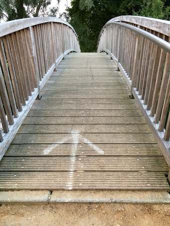 Old wooden bridge over a small riverの写真素材