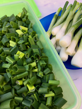 High angle view of fresh sliced ??spring onions in a green plastic boxの写真素材