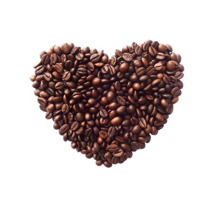 Heart shape made from coffee beans on white backgroundの写真素材