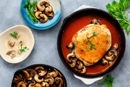 Baked chicken with mushrooms. In a black square dish, on a black table High quality photoの写真素材