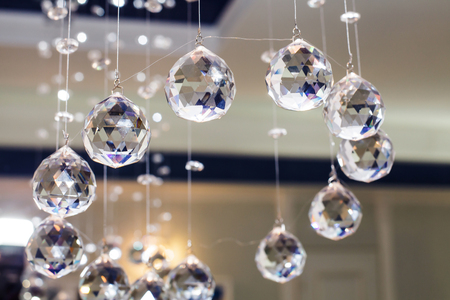 Swinging glass pendants light. Sparkling faceted pendulums. Rhythmic scent of pure crystals.の写真素材