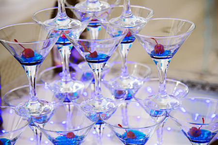 Pyramid from champagne glasses with cherries. Festive alcohol. Alcohol at the party.の写真素材