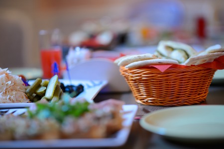 Wicker basket a festive table. Festive round table with food. Starched napkins and Cutlery. Festive meals. Restaurant inside. Service holidays. esign of the hall.の写真素材