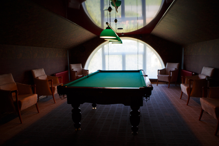 Pool table natural slate covered with green cloth. The movement of the balls with the cue - male fun.の写真素材