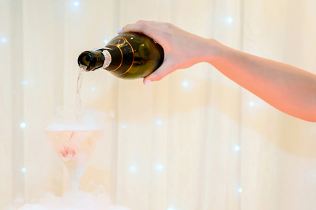 Pouring champagne into glasses of alcohol a holiday party. Service restaurant business.の写真素材