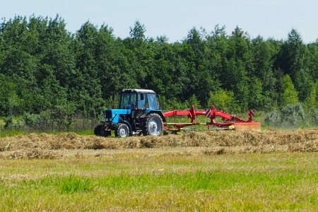 Work on a farmer's field machine for stacking the hay stacks.の写真素材