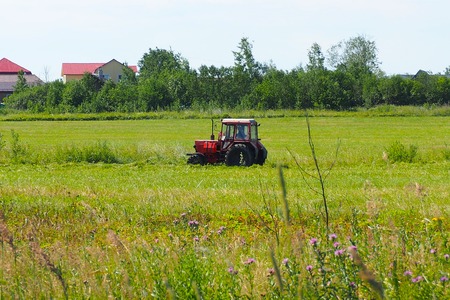 Work on a farmer's field machine for stacking the hay stacks.の写真素材