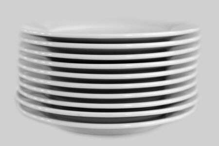 Stack of clean white plates on an isolated background.の写真素材