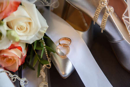 Shoes and a bridal bouquet with rings.の写真素材