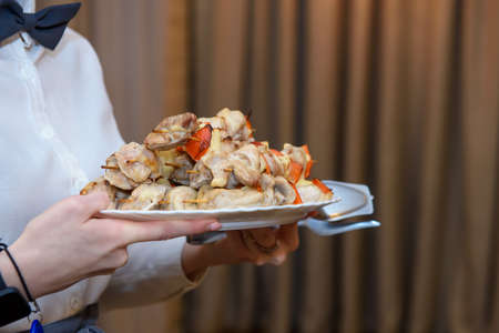 The hands of the waiter serving the guests.の写真素材