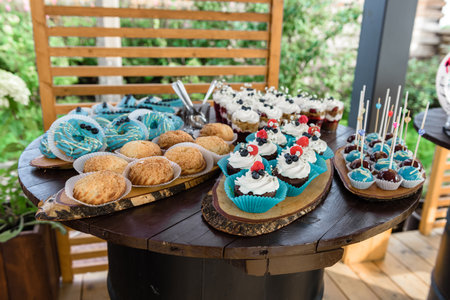 Cupcakes with blue frosting and cupcakes on a wooden tableの写真素材