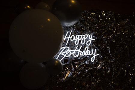 Happy Birthday greeting card with silver and white balloons on dark background.