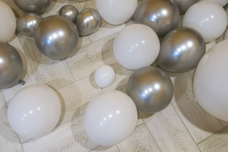 White and silver balloons on the floor of a modern living room.の写真素材