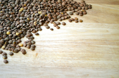 uncooked lentils on wooden cutting boardの写真素材