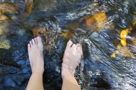 soaking feet in cold stream waterの写真素材