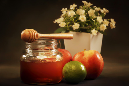Honey jar with wooden drizzler and apple,lemon on canvas backgroundの写真素材