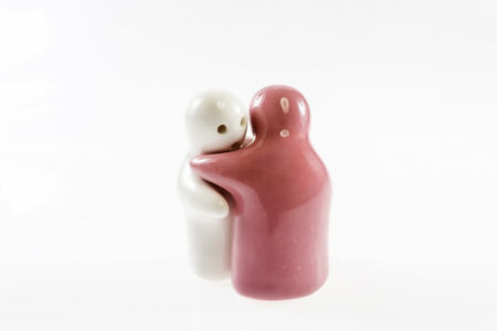 A couple love of human ceramic toy hugging. Isolated on white background.の写真素材