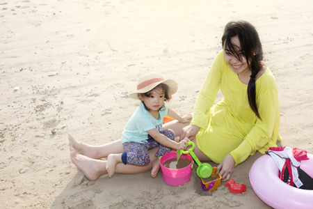 Mother with little girl playing on the beach  in the evening.の写真素材