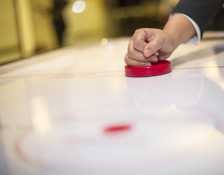 Hand on a mallet over air hockey tableの写真素材